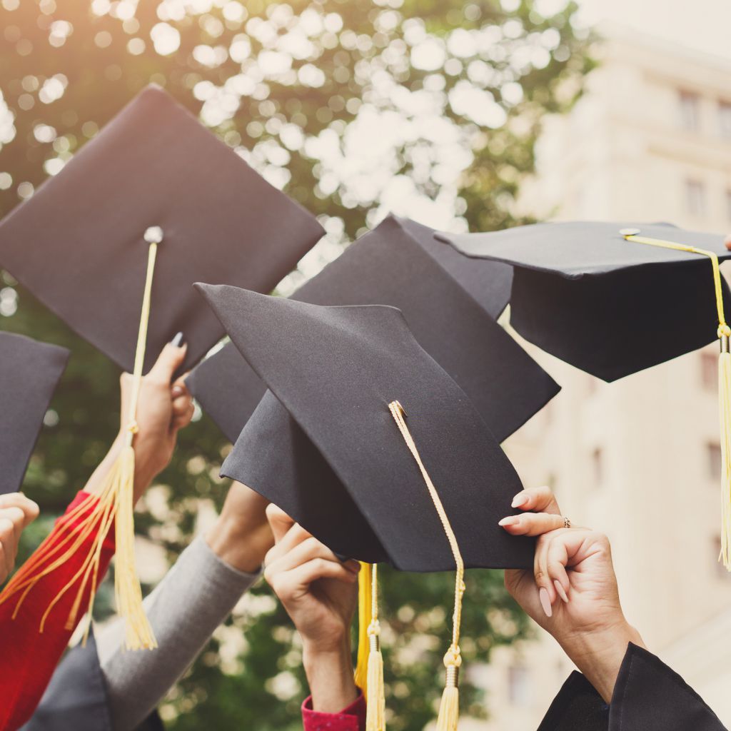 A group of graduates throwing graduation caps in the air